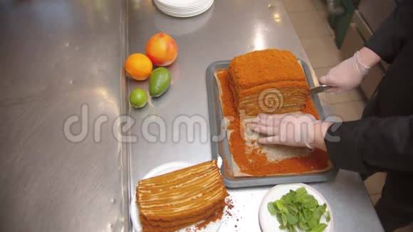 厨师用锋利的刀切出一大块蜂蜜蛋糕水果躺在桌子上视频的预览图