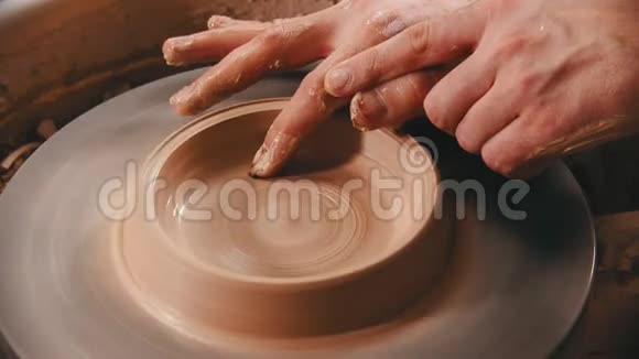 陶工用手指在陶工的轮子上做陶碗底部视频的预览图