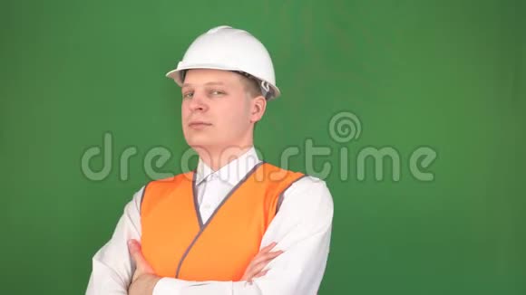 一个穿着信号背心和建筑白色头盔的年轻人站在那里看着卡姆鲁背景色彩视频的预览图