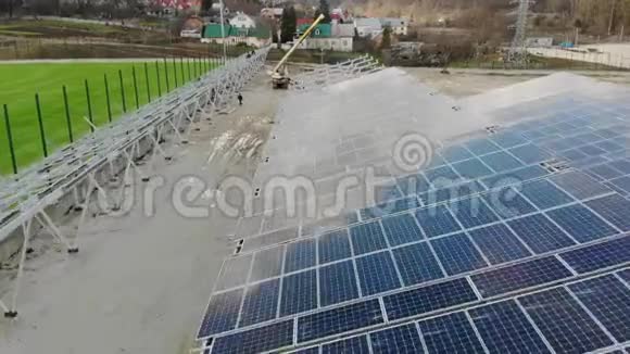 在太阳能电池板发电厂上空飞行工人安装太阳能电池板并将为工厂供电视频的预览图
