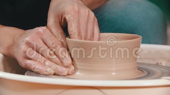 陶器主人正举起陶碗的墙壁双手放在创意车间的陶工轮子上视频的预览图