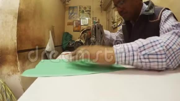 印度裁缝在老式缝纫机上缝制小作坊脏墙视频的预览图
