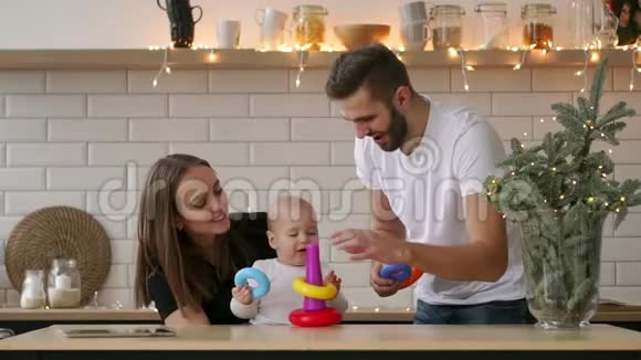 有新生儿的幸福年轻家庭母亲父亲和新生婴儿快乐的爸爸妈妈亲吻拥抱婴儿视频的预览图