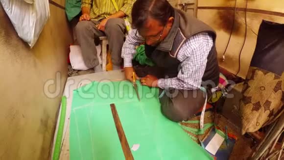 印度裁缝用大剪刀缝制车间Bikaner从绿色材料中裁剪图案视频的预览图