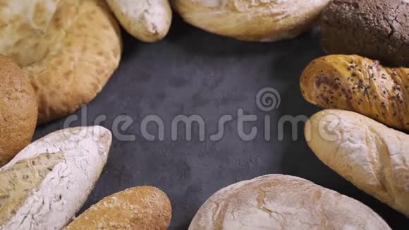 背景与不同类型的面包旋转全麦新鲜面包摆在桌子上视频的预览图