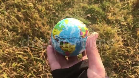 女性手握全球地球对抗黄草生态理念人类冲击拯救地球视频的预览图