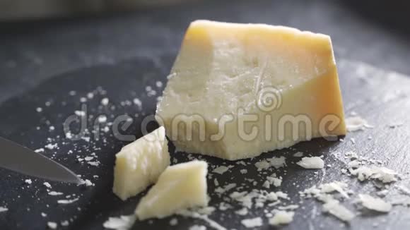 意大利奶酪的组成在黑色的切割板上一只手拿着刀打碎了几块视频的预览图