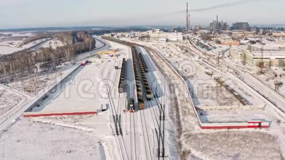 在冬季观景台上车站装载着煤车提供带有货车和站立列车的货运列车超高清4K航空视野视频的预览图