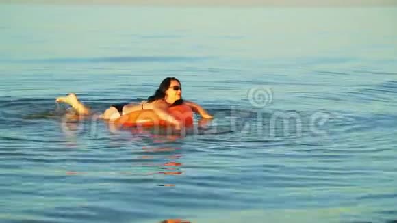 一位身穿泳装的黑发女子在靠近海岸的海域游泳视频的预览图