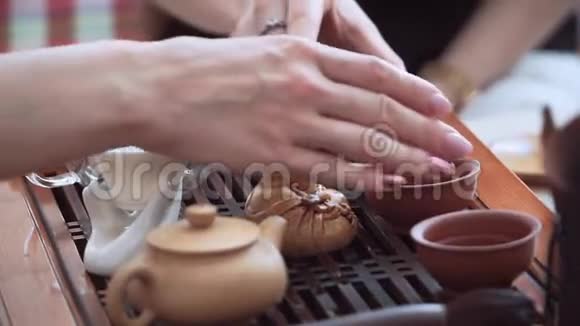 女孩的手分开把茶杯放到木桌上茶道视频的预览图