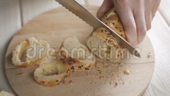 用面包刀在厨房的木切割板上切割法国面包视频的预览图
