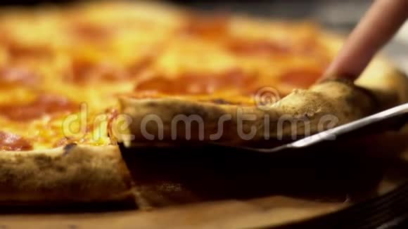 斯帕图拉拿了一片意大利腊肠披萨融化奶酪的特写快餐的概念视频的预览图