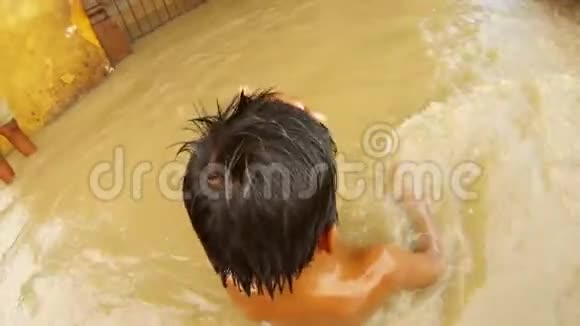 两个印度小男孩在混乱的水中洗澡洪水淹没了贝拿勒斯码头上的圣河恒河马尼卡尼卡加特船视频的预览图