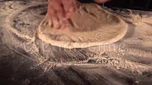厨师的手用面粉揉捏桌子上的面团披萨店准备意大利香肠烹饪过程视频的预览图