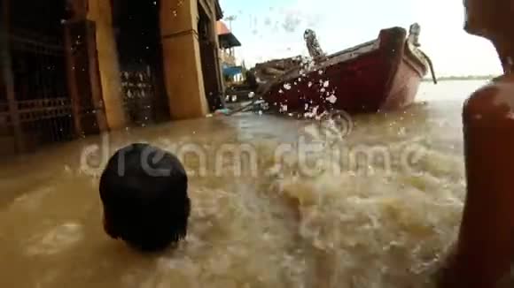 两个印度小男孩在瓦拉纳西号码头被洪水淹没的恒河水面上溅起水花视频的预览图