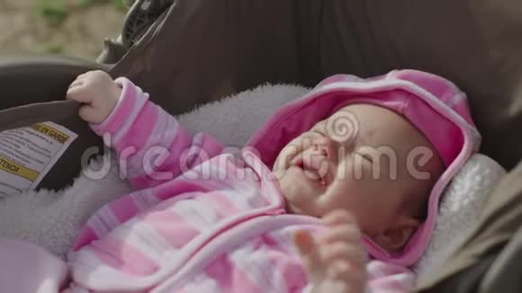 春日小女孩躺在婴儿车里的特写镜头视频的预览图