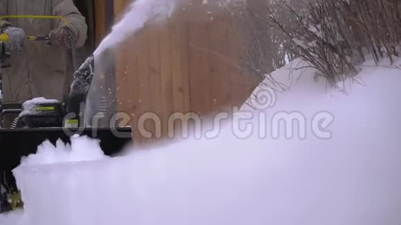 一个人用吹雪机在人行道上清扫积雪视频的预览图