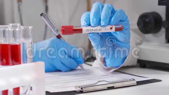 冠状病毒血液检测带防护手套的女实验室技术人员在医院检测血样视频的预览图