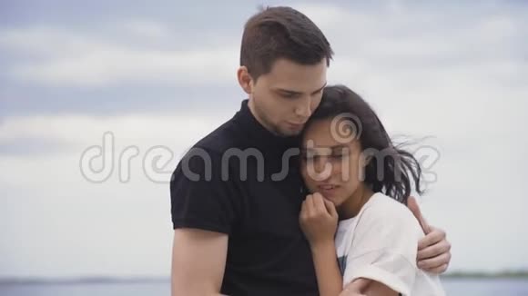 浪漫的年轻夫妇拥抱在公园的天空背景视频的预览图
