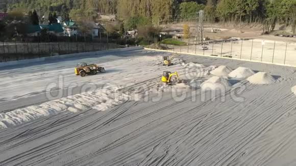 挖掘机用沙子使场地平整从土堆中移动沙子视频的预览图