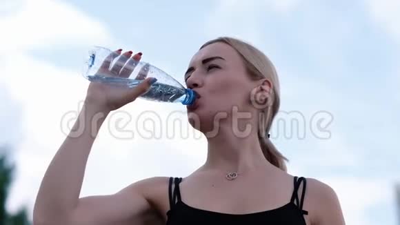年轻运动的女人从瓶子里喝静水健身和生活方式概念视频的预览图