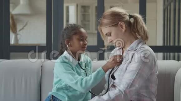 带着听诊器的快乐女孩和妈妈扮演医生视频的预览图