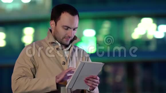 成熟的男人晚上用平板电脑视频的预览图