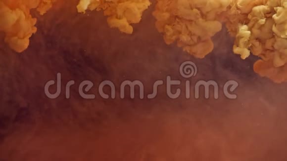 橙色的颜料滴在水中五颜六色的墨水云在水中蔓延视频的预览图