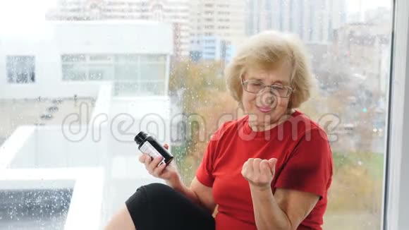 保健和老年人的概念老妇人一只手拿着一个药丸容器另一只手拿着药丸有效有效视频的预览图