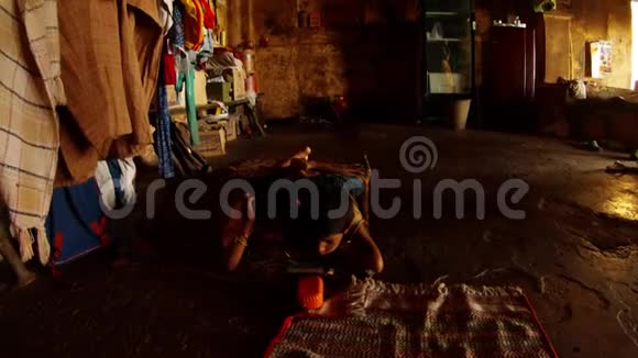 两个印度男孩躺在地板上看电话看着一堆衣服干脏破旧的墙壁瓦拉纳西的贫民窟视频的预览图