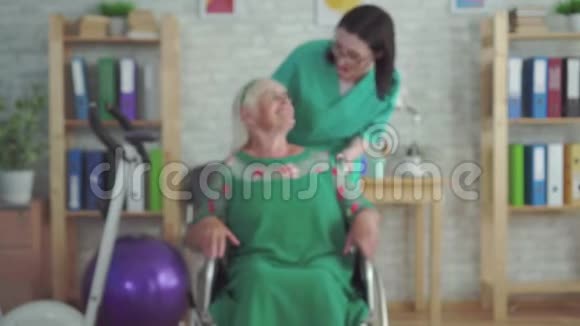 坐在轮椅上微笑的老年妇女的肖像视频的预览图