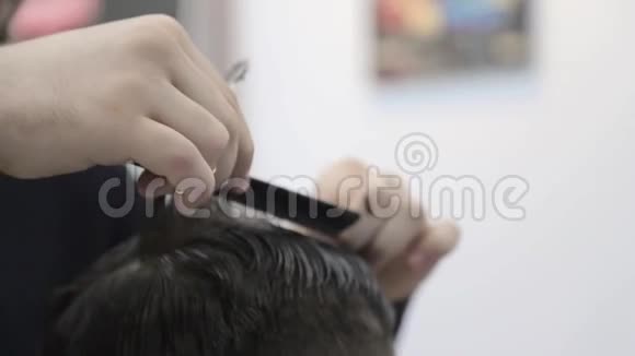 理发师用剪刀把顾客头发剪在椅子上特写剪头剪去头发视频的预览图