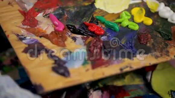 木制艺术调色板与油画把颜色混合在一起视频的预览图