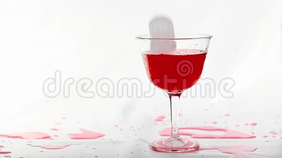 冰块掉下来溅到红色新鲜酒精鸡尾酒饮料白色背景拍摄慢动作视频的预览图