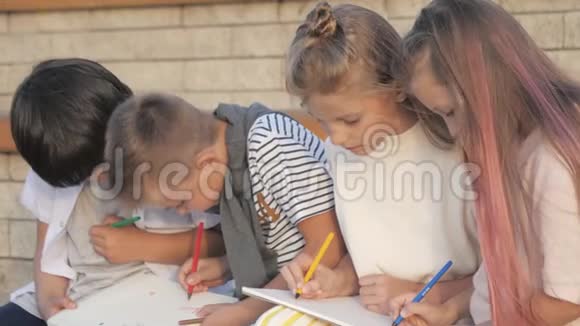 四个孩子坐在户外画画视频的预览图