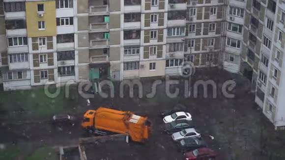 一辆垃圾车开进院子去捡垃圾箱春天城市里的暴风雪慢动作视频的预览图