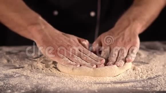 男人的手在面粉里揉比萨饼面团擀面团的特写视频的预览图