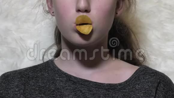 年轻的白种人小女孩吃脆皮薯片用薯片做鸭嘴唇视频的预览图