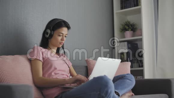 一位严肃的年轻女性自由职业者在家工作在笔记本电脑上打电子邮件视频的预览图