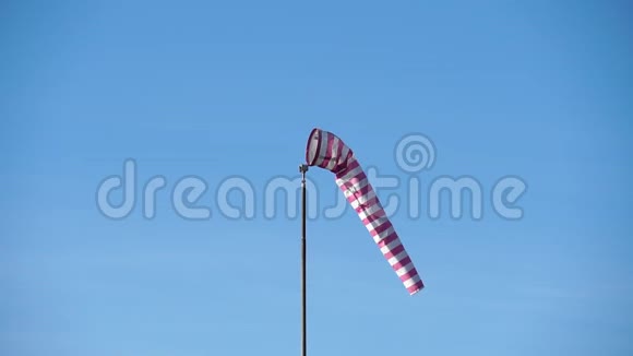 带有红白条纹的风锁显示了风的方向和速度蓝色天空背景下的锥形风向标视频的预览图