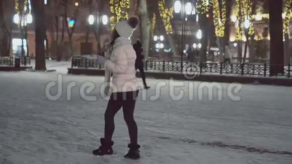 穿着温暖衣服的女孩在假日街上散步视频的预览图