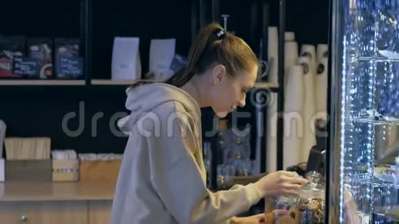 漂亮的女人在咖啡馆的展示桌上选择咖啡饼干视频的预览图