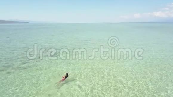 一位游客在菲林岛一片清澈的海洋里游泳的鸟瞰图视频的预览图