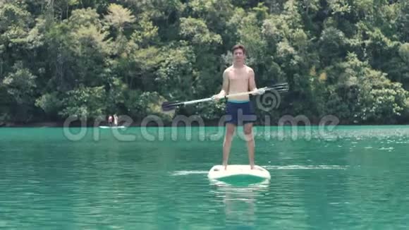 一个帅哥在站起桨板上跳舞享受暑假视频的预览图