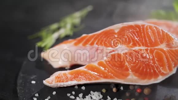 生的新鲜的三文鱼牛排放在石板和香料周围生三文鱼红鱼烹饪三文鱼海鲜视频的预览图