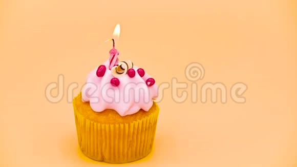 生日蛋糕上有一支红色的蜡烛在橙色的背景上视频的预览图