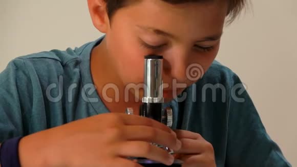 男孩拿起显微镜的镜头视频的预览图