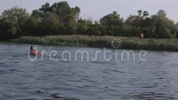 在摩托艇后的船上在芦苇的背景下水沿着河流溅起了一堆垃圾视频的预览图