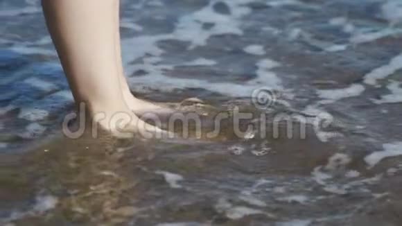 女性的双腿紧贴女人的脚和腿在海滩上行走视频的预览图