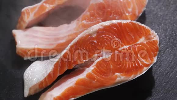 生的新鲜的三文鱼牛排放在石板和香料周围生三文鱼红鱼烹饪三文鱼海鲜视频的预览图
